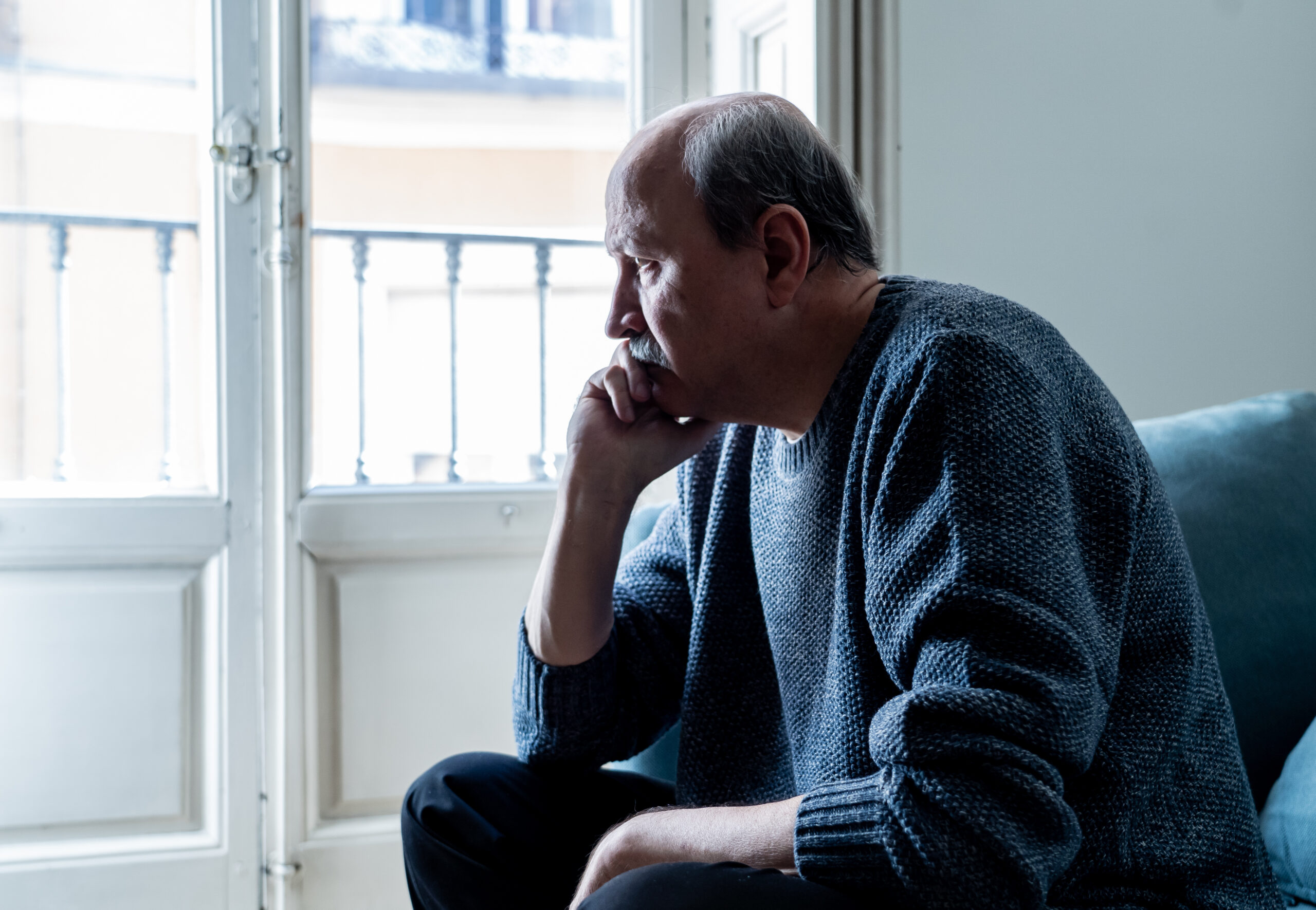 Sad unhappy old senior man suffering from memory loss and alzheimer feeling depressed and lonely